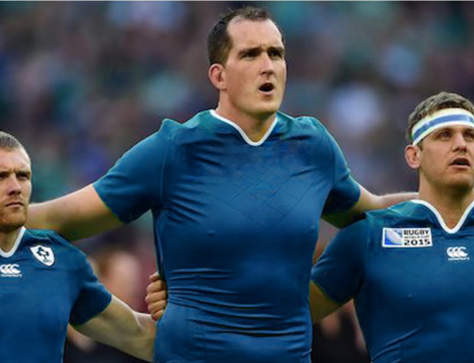 A very large rugby player standing out in a line up because of his different size