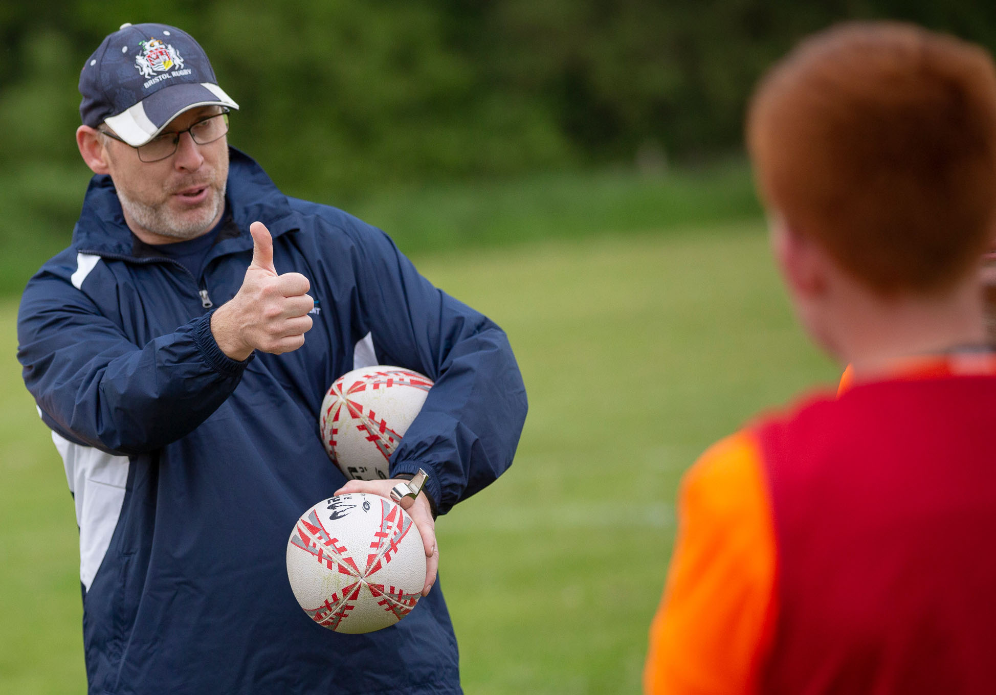 Switch Rugby director Matt Sheppard coaching young players and giving positive feedback with a thumbs up