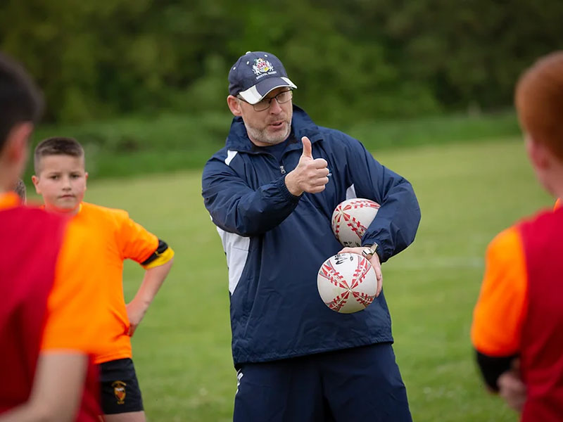 Switch Rugby Director Matt Sheppard coaching young players and giving a thumbs-up for positive feedback