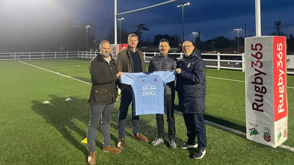 Switch Rugby - City of Bristol rugby club sponsors event with partners presenting jersey on rugby field at night